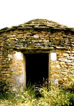 Montchalvy, Largentière (Ardèche) : cabane cylindrique à toiture conique avec larmier. Vue de l'entrée. © Christian Lassure.