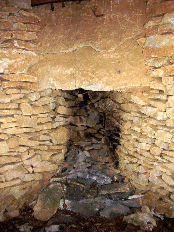 Cabane à Montsalier (Alpes-de-Haute-Provence) : cheminée ménagée à un angle de l'habitacle. Photo de Jean Laffitte.